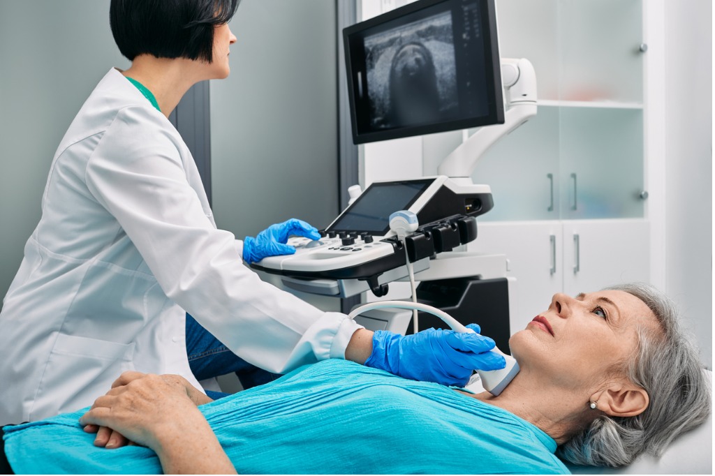 Ultrasound diagnostics of thyroid gland. Endocrinologist making ultrasonography to senior female patient at ultrasound office of medical clinic - National Diagnostic Imaging - November 4 2022